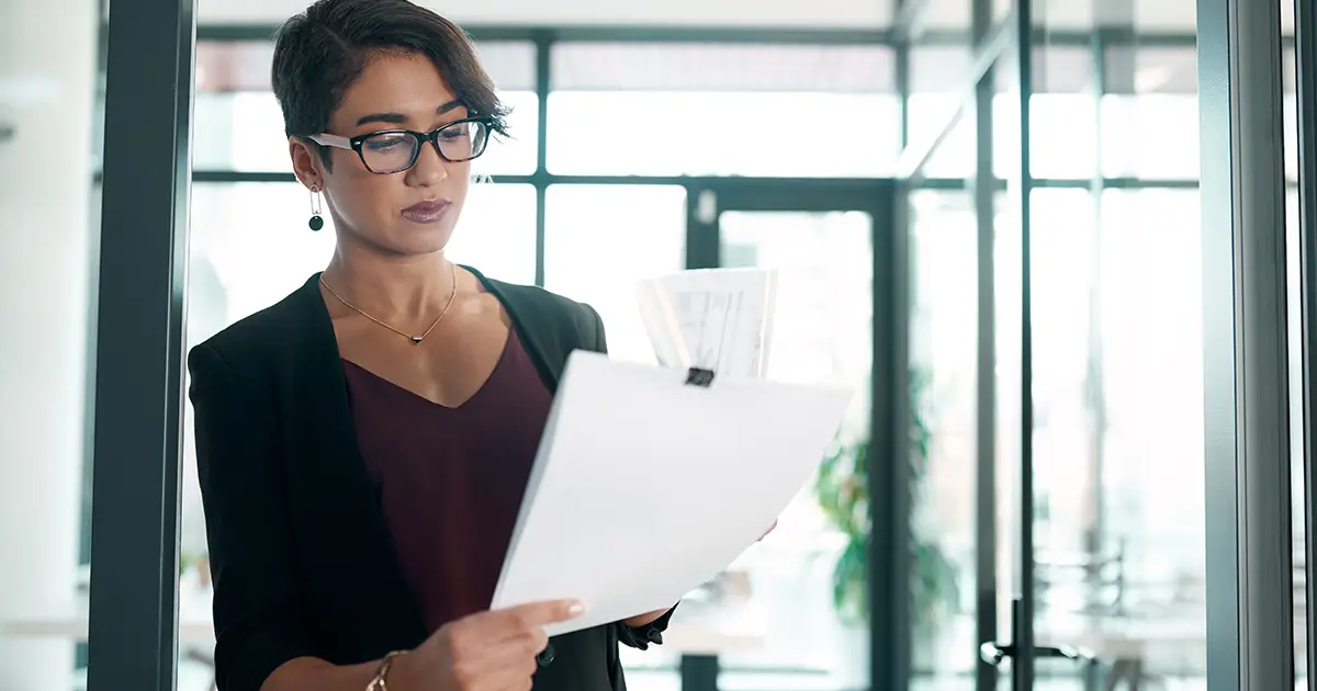 business woman standing alone in the office and reading paperwork