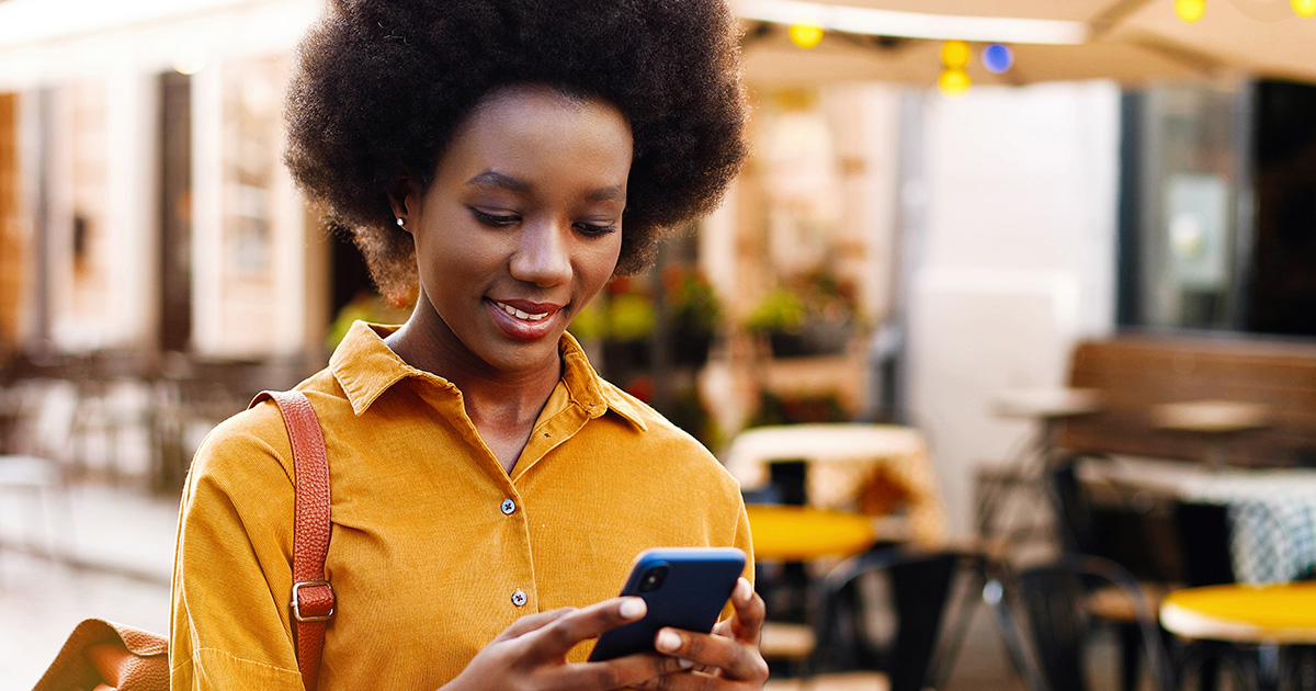 Close up of happy woman viewing credit-score on smartphone on street