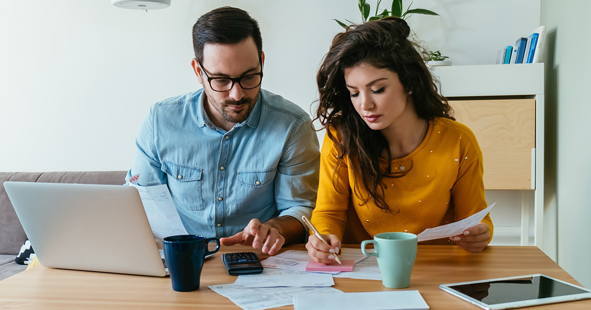 Couple sitting at desk reviewing documents