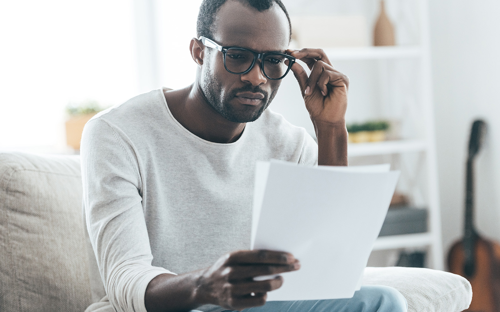 Man with glasses looking at sheets of paper