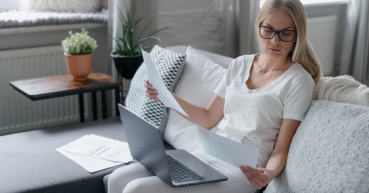 Looking at documents and sitting on sofa