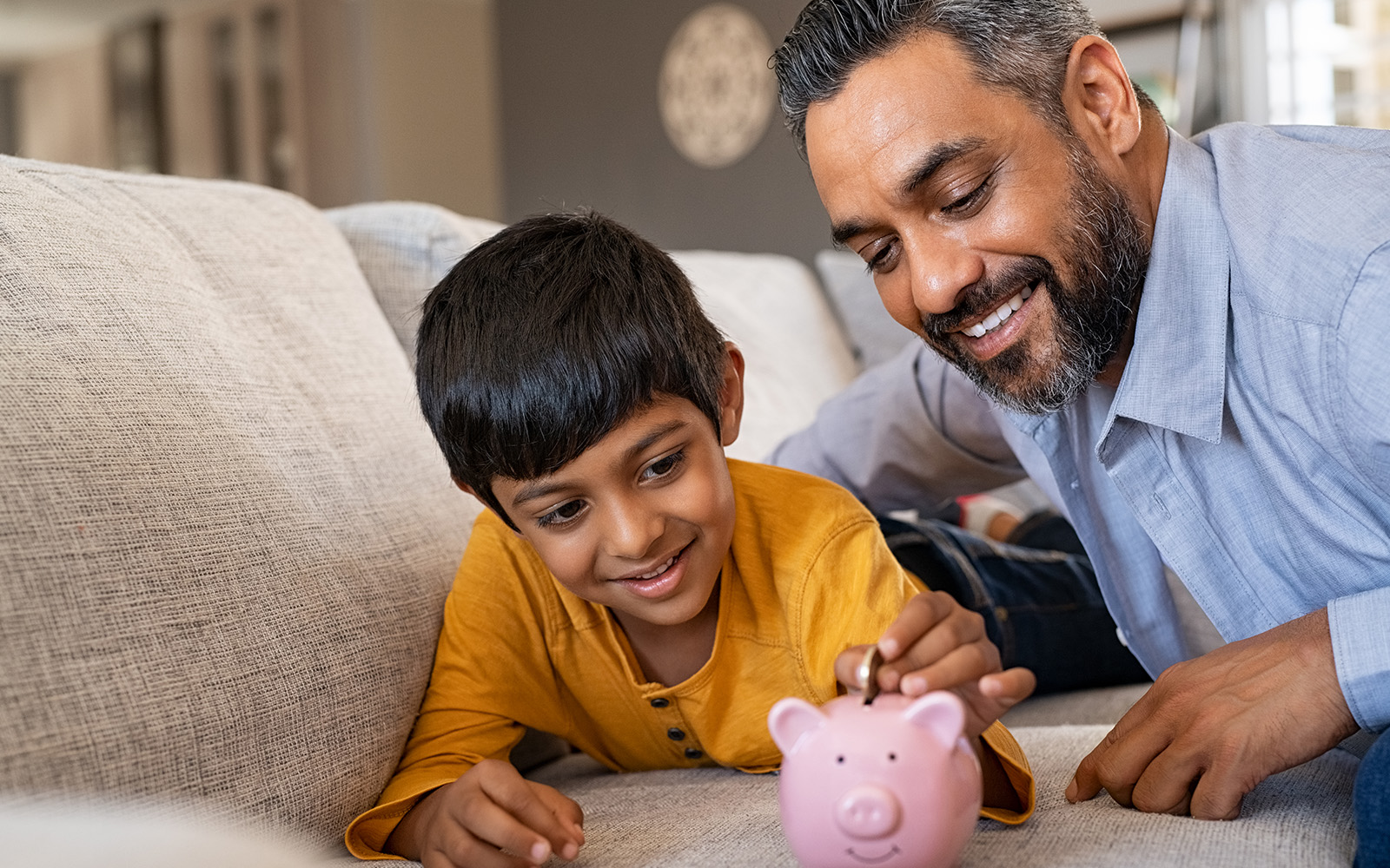 A father and son playing with a piggy bank