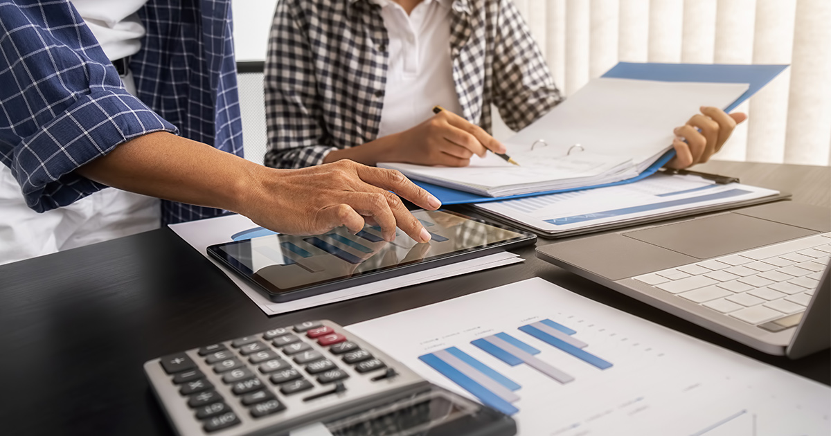 Couple brainstorming and discussing with financial data and report graph