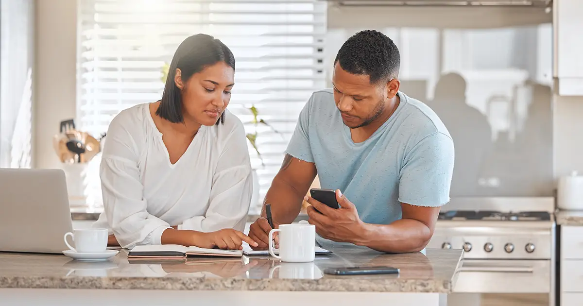 Shot of a couple going over paperwork together at home, calculating monthly expenses.