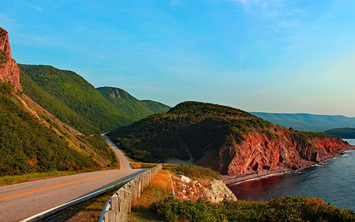 Open road way following along the coastline heading into mountain region