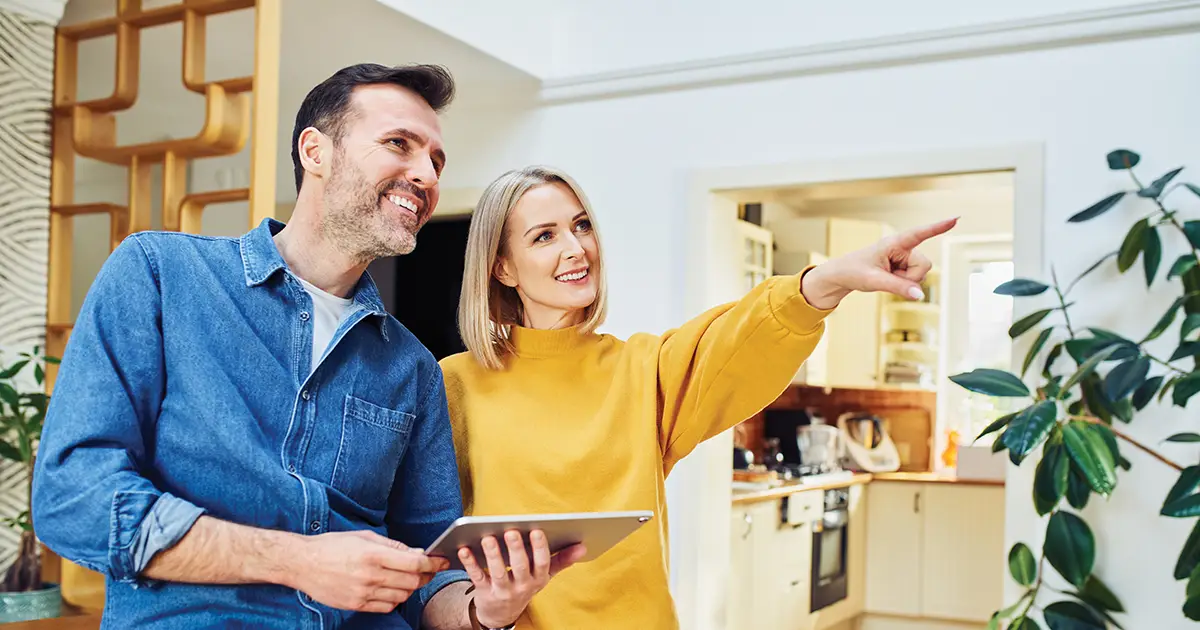 Smiling couple planning home renovation standing in living room