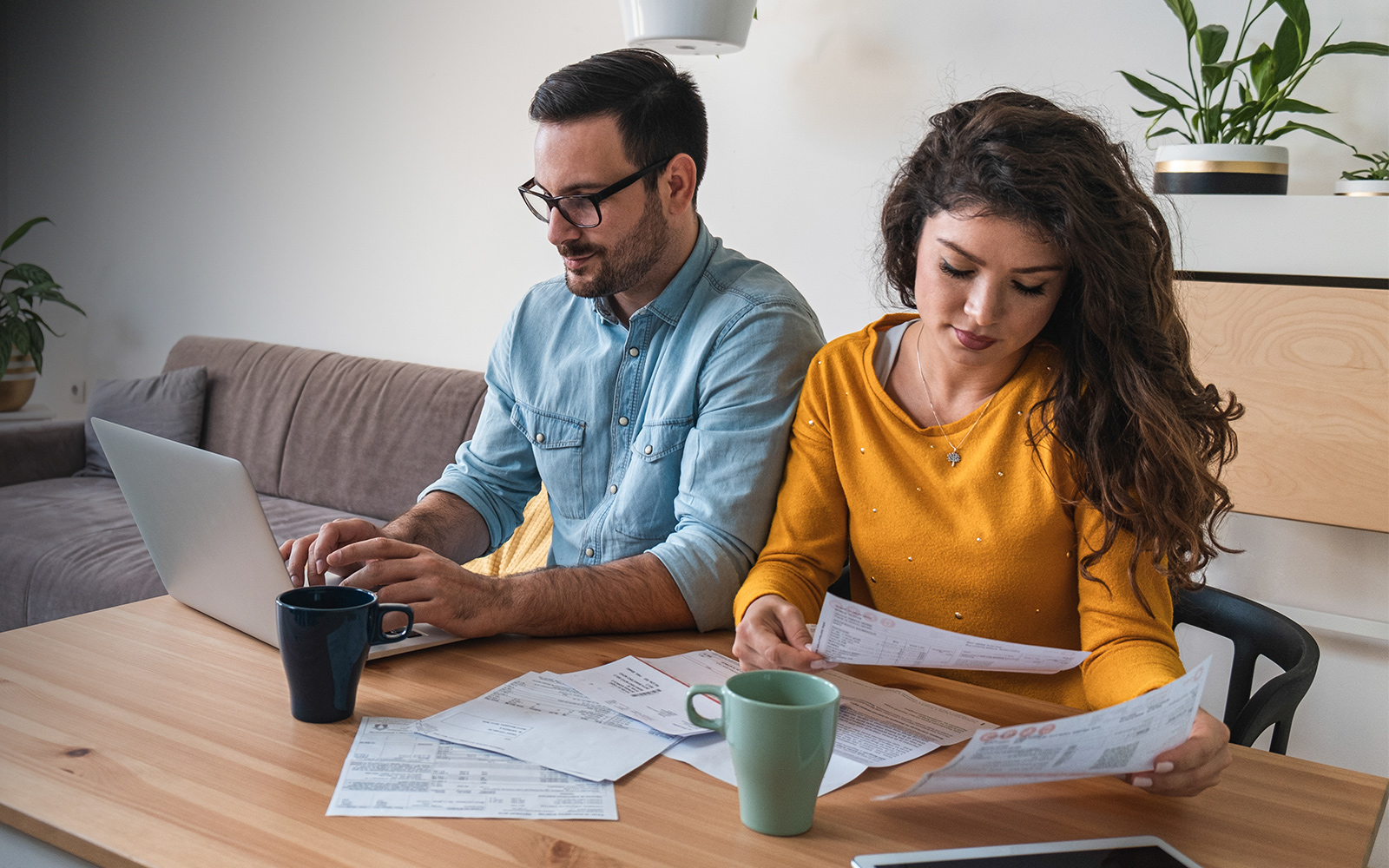 Focused married couple manage finances using internet 