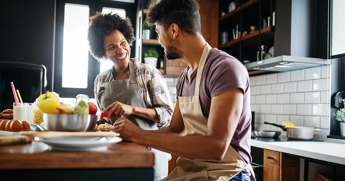 Happy couple preparing healthy food in kitchen