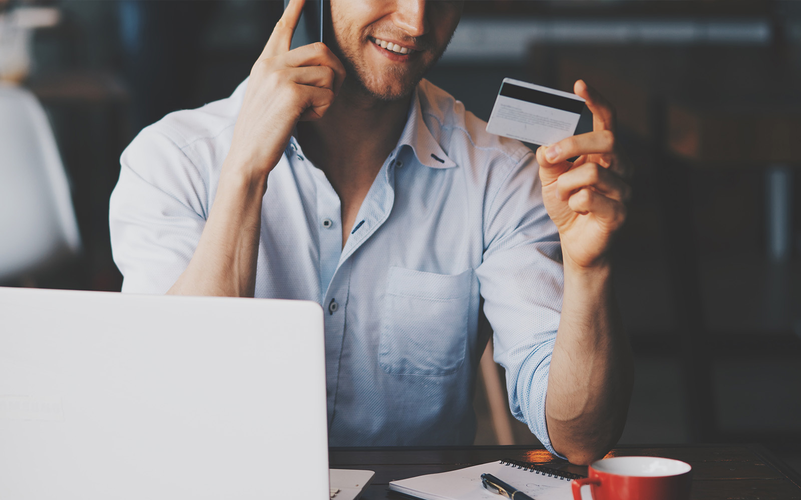 Young business man using credit card shopping online in coffee shop cafe