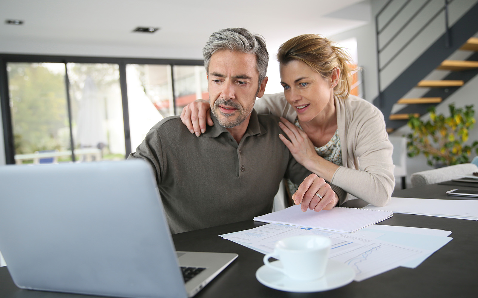 Mature couple calculating financial savings on internet