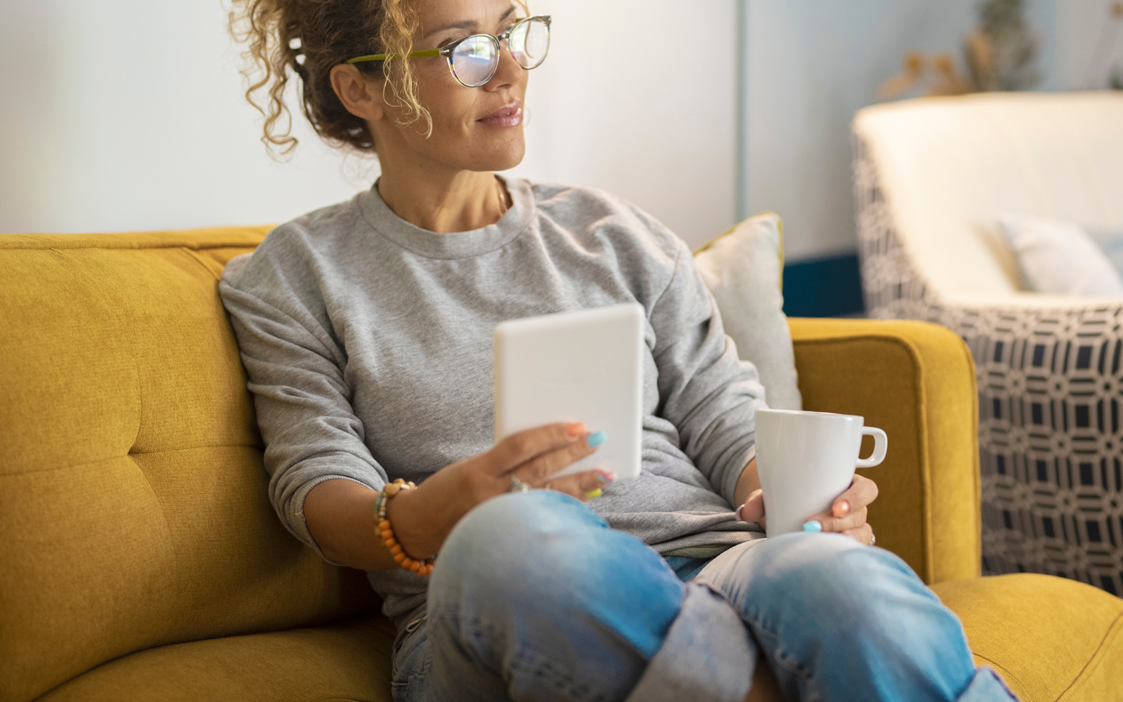 woman sitting on sofa drinking coffee