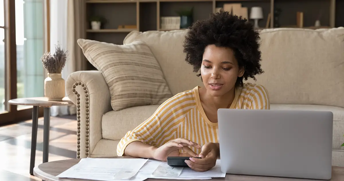 woman makes calculations on calculator to pay bills