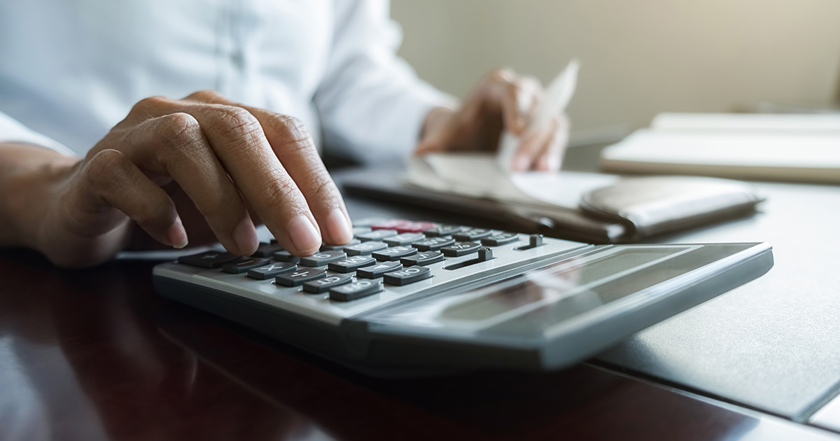 Woman with bills and calculator looking at her budget