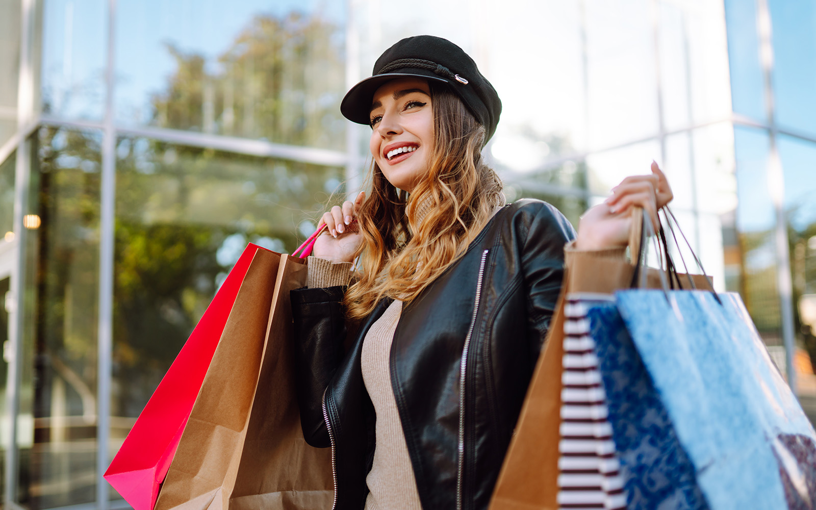 Woman with shopping bags walks through the city streets Spring Style Consumerism Shopping