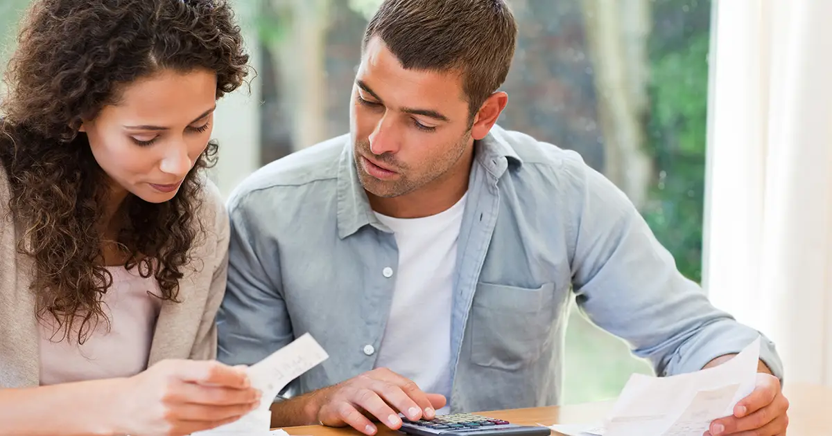 Young couple calculating their domestic bills at home.