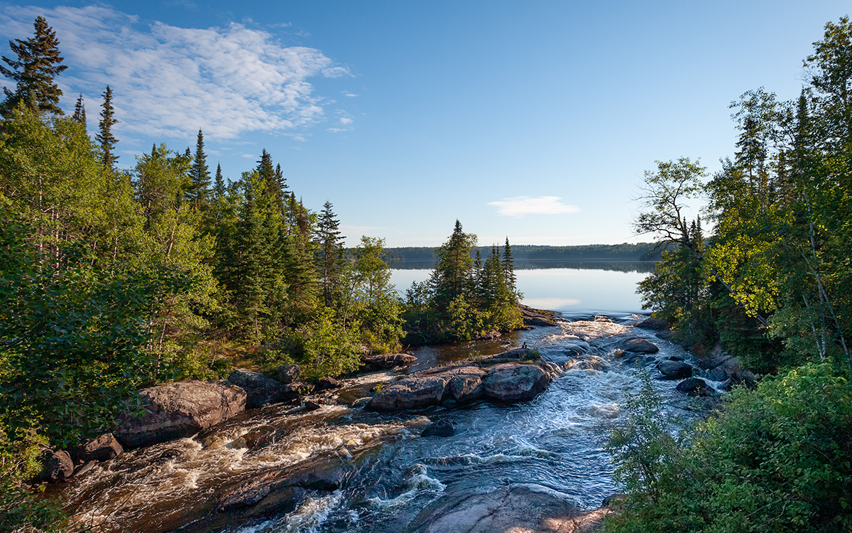 river flowing into lake with trees around