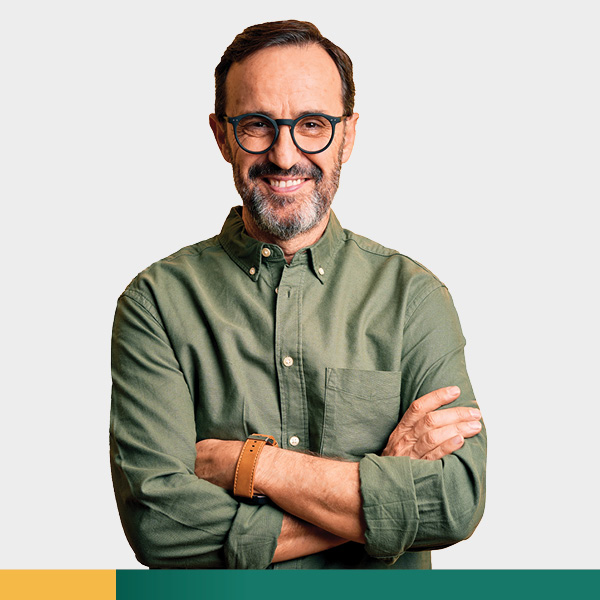 Man in green shirt smiling with arms crossed