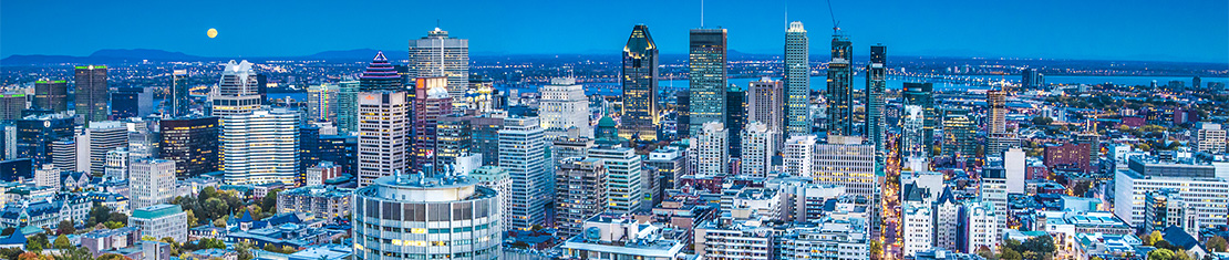 Downtown Montreal at dusk with a full moon hanging low in the sky