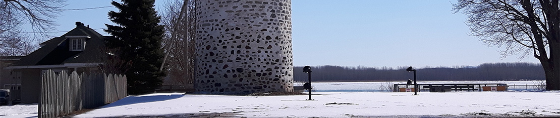 Farmhouse and old brick silo surrounded by a field of snow